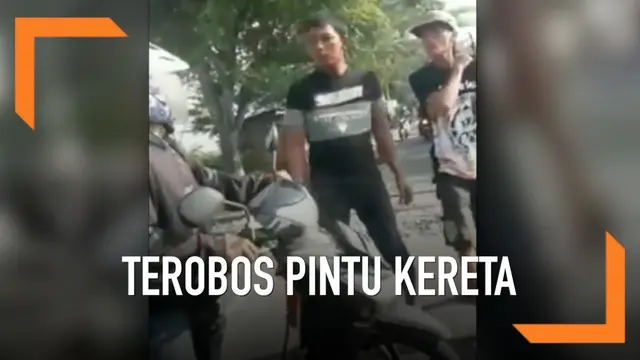 Seorang pemotor terima nasib apes lantaran nekat menerobos pintu kereta. Alhasil ia harus terima amarah dari dua penjaga perlintasan.