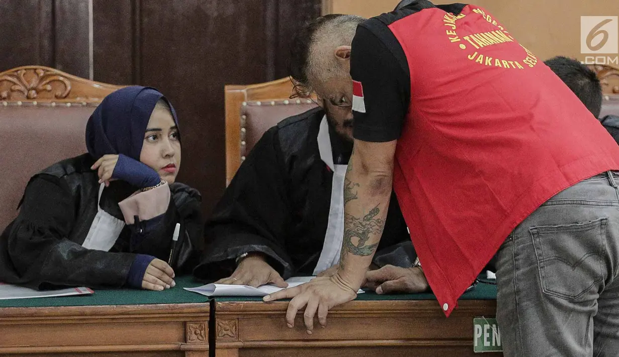 Tio Pakusadewo berdiskusi dengan kuasa hukumnya disela sidang pembacaaan dakwaan kasus penyalahgunaan narkoba di PN Jakarta Selatan, Senin (30/4). Sidang lanjutan dengan menghadirkan sejumlah saksi digelar pada 7 Mei 2018. (Liputan6.com/Faizal Fanani)