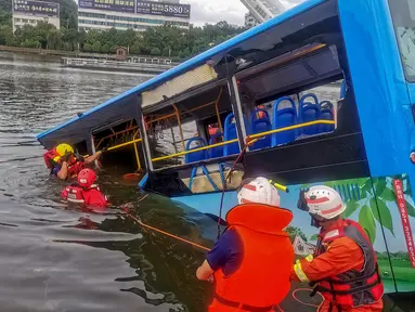 Tim penyelamat berusaha mengevakuasi sebuah bus yang jatuh ke danau di Anshun, provinsi Guizhou, China, Selasa (7/7/2020). Sedikitnya 21 orang tewas usai bus yang  membawa siswa untuk mengikuti ujian masuk perguruan tinggi atau gaokao itu menabrak pagar pembatas lalu tercebur ke danau. (STR/AFP)