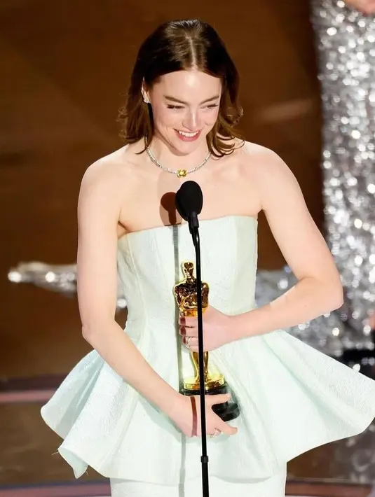 Tepat setelah Emma turun dari panggung, timnya menjahit gaunnya kembali. Ia mengatakan kepada para wartawan di belakang panggung setelah kemenangannya bahwa pengalaman tersebut terasa luar biasa untuknya. [Foto: Instagram/emmagemstone]