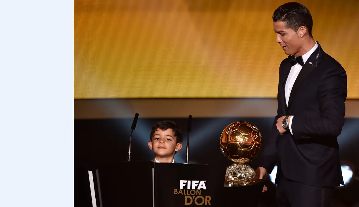 Cristiano Ronaldo didampingi anaknya, Cristiano Jr, saat menerima trofi FIFA Ballon d'Or sebagai Pemain Terbaik Dunia 2014. 12 Januari 2015. (AFP/Fabrice Coffrini)