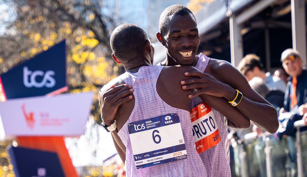 Pelari Kenya, Benson Kipruto (kiri) dan kompatriotnya, Alexander Mutiso berpelukan setelah melintasi garis finis pada ajang New York Marathon 2025 pada Minggu (02/11/2025) waktu setempat. Ini menjadi finis dengan jarak terdekat dalam ajang maraton dengan selisih 0,03 detik. (AP Photo/Angelina Katsanis)