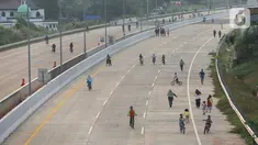 Warga berolahraga sepeda dan berlari pada waktu sore di kawasan pembangunan Tol Serpong Kunciran, Ciputat, Tangerang Selatan, Kamis (25/6/2020). Pembangunan tol yang belum rampung dimanfaatkan sejumlah warga beraktivitas selama pandemi Covid-19. (Liputan6.com/Fery Pradolo)