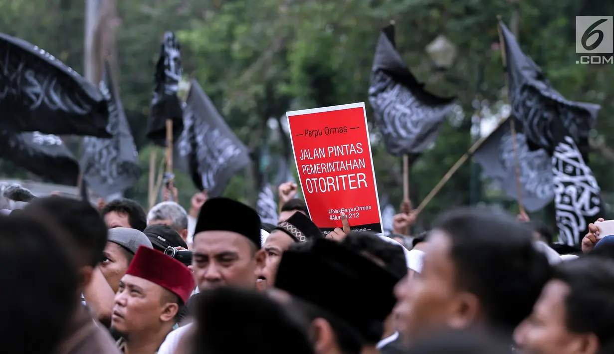 Peserta aksi membawa poster saat berunjuk rasa di Pintu Barat Monas, Jakarta, Selasa (18/7). Terlihat massa memadati pintu Barat Monas dengan membawa atribut aksi spanduk dan bendera. (Liputan6.com/Faizal Fanani)