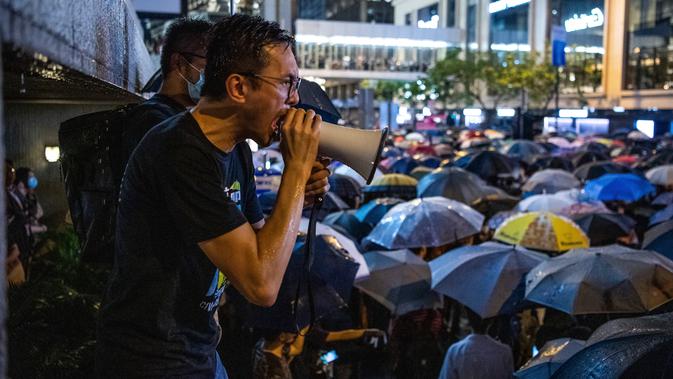 Seorang pria berteriak menggunakan pengeras suara saat ribuan pegawai negeri sipil (PNS) mengikuti unjuk rasa menolak RUU Ekstradisi di Hong Kong, Jumat (2/8/2019). Aksi para pegawai negeri sejatinya telah ditentang oleh pemerintah Hong Kong. (LAUREL CHOR/AFP)