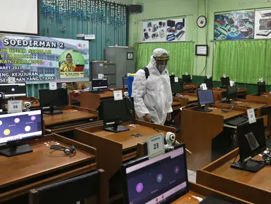 Petugas melakukan penyemprotan cairan disinfektan jelang dibukanya pembelajaran tatap muka di SMK PB Soedirman 2, Jakarta, Selasa (6/4/2021). Pemprov DKI Jakarta akan melakukan uji coba pembelajaran tatap muka di 100 sekolah mulai 7 April hingga 29 April 2021. (Liputan6.com/Herman Zakharia)