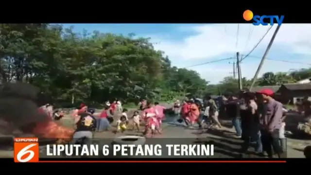Warga memasang palang dan bakar ban bekas sebagai aksi protes terkait jalan rusak di kecamatan Rumpin Bogor.