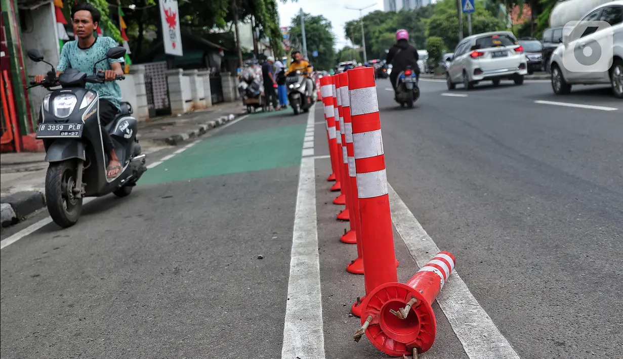 Pengendara bermotor melintas di samping stick cone pembatas jalur sepeda di Kawasan Jalan Penjernihan Jakarta, Sabtu (10/12/2022). Keadaan stick cone untuk pembatas jalur sepeda tersebut terlihat sudah rusak dan tidak terpasang dengan benar. (Liputan6.com/Angga Yuniar)