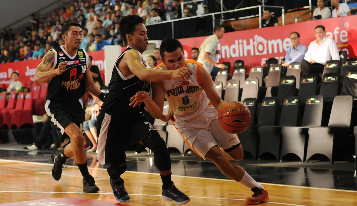 Pebasket Pelita Jaya Energi Mega Persada Jakarta, Faisal Achmad (kanan) berusaha melewati hadangan dua pemain Hang Tuah Sumsel di NBL Championship, Jakarta, Sabtu (2/5/2015). Pelita Jaya unggul 73-58 atas Hang Tuah. (Liputan6.com/Helmi Fithriansyah)