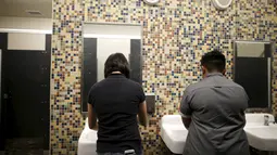 Dua siswa mencuci tangan mereka di toilet netral gender pertama di Santee High School, Los Angeles, California, AS, Senin (18/4). Toilet disediakan sebagai langkah mendukung dan menampung siswa transgender. (REUTERS/Lucy Nicholson)