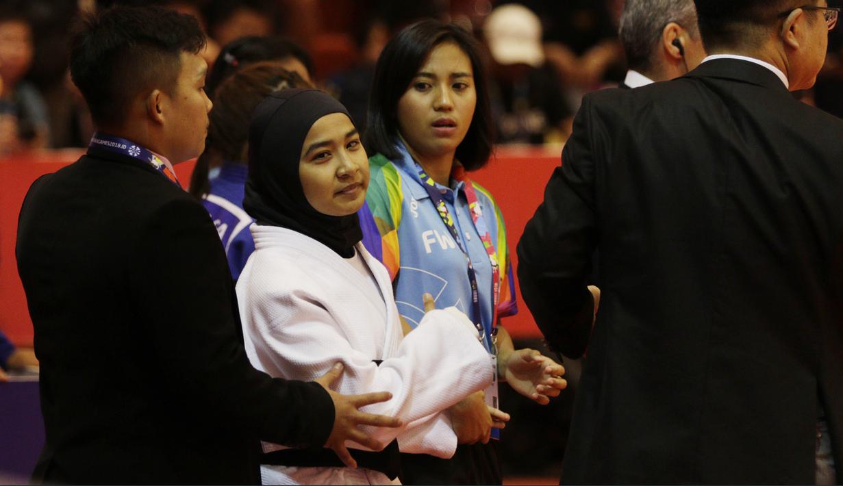 Atlet Judo Indonesia, Miftahul Jannah, meninggalkan lokasi pertandingan usai gagal berlaga pada Asian Para Games di Jiexpo, Kemayoran, Jakarta, Senin (8/10/2018). Miftah didiskualifikasi karena enggan melepas hijab nya. (Bola.com/M Iqbal Ichsan)