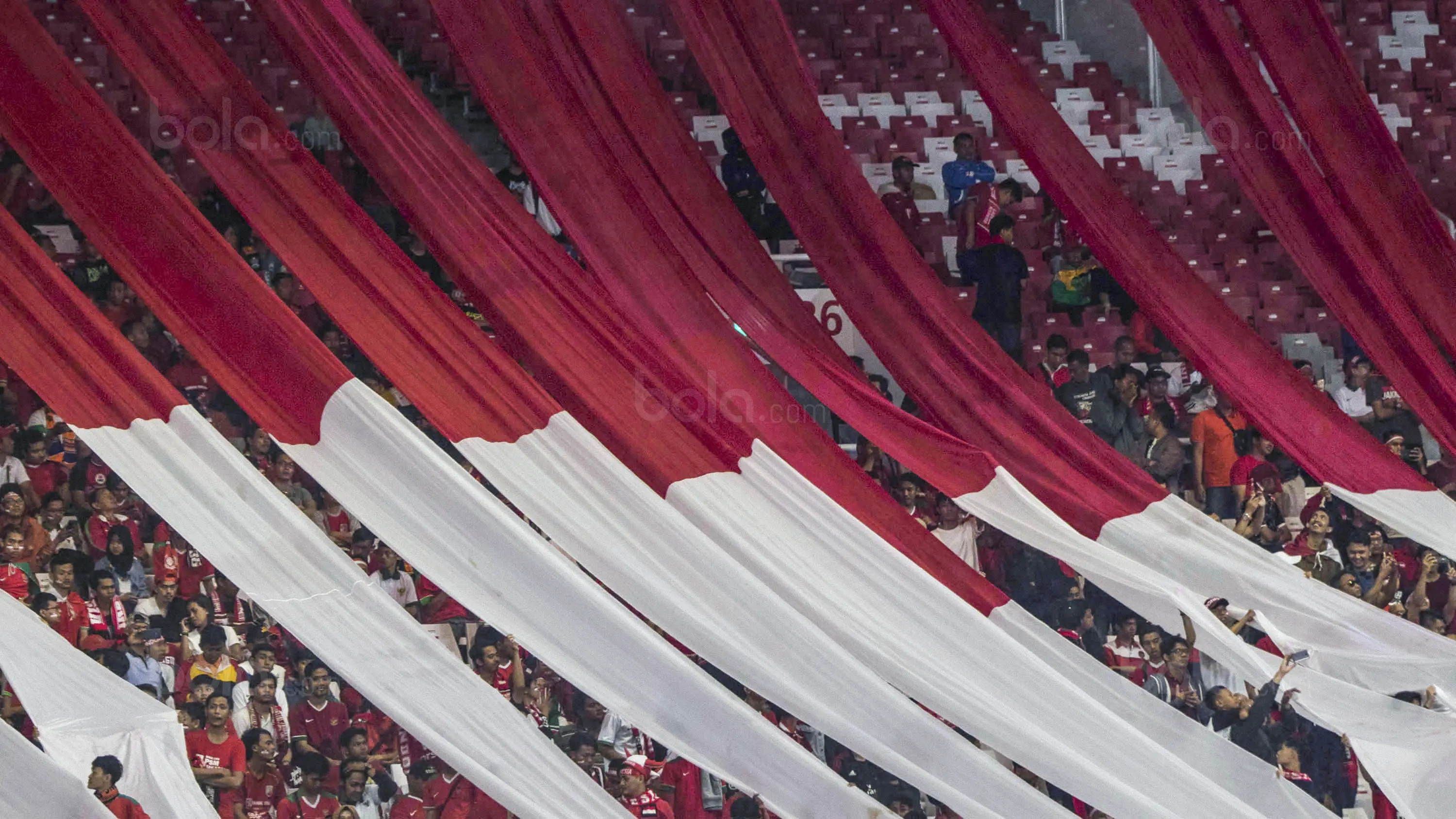 Suporter membentangkan bendera raksasa saat laga persahabatan antara Timnas Indonesia melawan Islandia di Stadion Utama Gelora Bung Karno, Jakarta, Minggu (14/1/2018). Timnas Indonesia kalah 1-4 dari Islandia. (Bola.com/M Iqbal Ichsan)