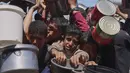 Warga Palestina berebut untuk mendapat pembagian makanan di sebuah dapur umum, Khan Younis, Jalur Gaza selatan, Senin 2 Juni 2025. (AP Photo/Abdel Kareem Hana)