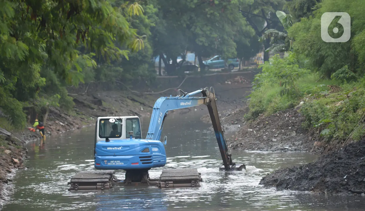 Pekerja mengoperasikan alat berat excavator untuk mengangkat material endapan lumpur di kanal sungai perkantoran Kuningan Jakarta, Rabu (17/2/2021). Pengerukan dilakukan untuk memperlancar aliran air agar tidak terjadi pendangkalan yang mengakibatkan genangan air. (merdeka.com/Imam Buhori)