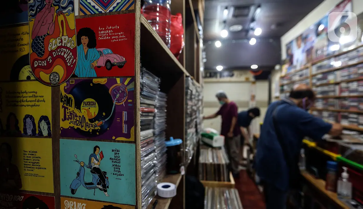 Pecinta musik memilah Piringan Hitam, CD, dan Kaset pita di toko "Wow Record Store", Blok M Squere, Jakarta, Jumat (12/3/2021). Pedagang Piringan Hitam, CD, dan Kaset Pita ini bertahan ditengah Perkembangan era digital dan Pandemi. (Liputan6.com/Johan Tallo)