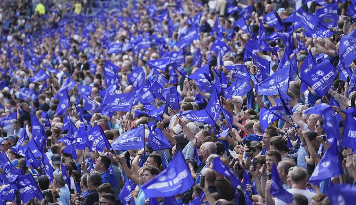 Suporter Everton melakukan koreografi dengan mengibarkan bendera dalam laga Liga Inggris melawan Brighton di Hill Dickinson pada Minggu (24/08/2025) waktu setempat. (AP Photo/Jon Super)