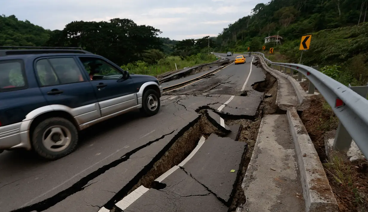 Sebuah mobil melewati jalanan retak setelah diguncang gempa 7,8 SR di Chone, Ekuador, Minggu (17/4). Menurut pihak berwenang, gempa kuat tersebut setidaknya menewaskan 246 orang dan menghancurkan bangunan serta jembatan. (Juan Cevallos/AFP)