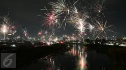 Tampak kembang api menghiasi langit Jakarta saat malam pergantian tahun di kawasan Banjir Kanal, Petamburan, Jakarta, Minggu (01/1). (Liputan6.com/Johan Tallo)