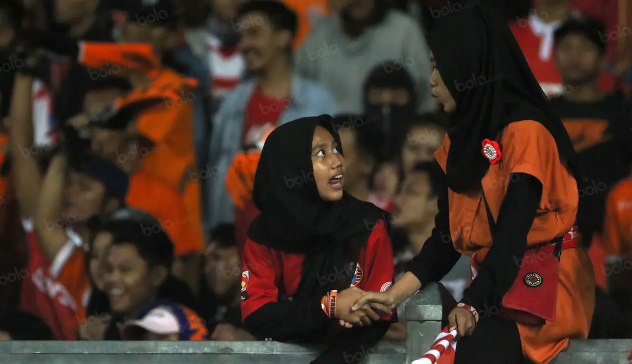Dua suporter Persija Jakarta berkenalan saat mendukung timnya melawan Sriwijaya FC di Stadion Utama Gelora Bung Karno pada laga Torabika SC 2016, (24/6/2016).  (Bola.com/Nicklas Hanoatubun)