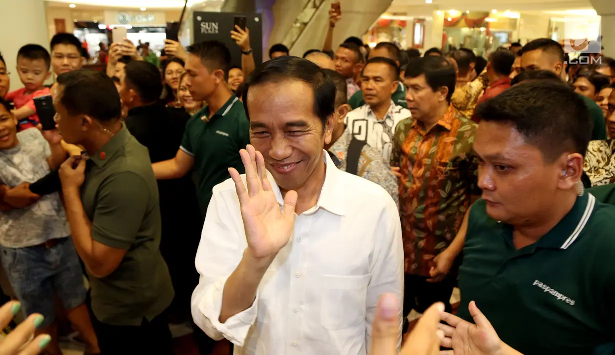 Presiden Joko Widodo menyapa warga ketika tiba di Sun Plaza Medan, Sumatera Utara, Jumat (24/11). Jokowi tiba mengenakan kemeja putih lengan panjang dan celana hitamnya sambil menebar senyum. (Liputan6.com/Johan Tallo)