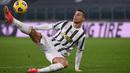 Penyerang Juventus, Cristiano Ronaldo menendang bola setelah kehilangan keseimbangan saat menghadapi Crotone dalam lanjutan Liga Italia di Allianz Stadium, Selasa dinihari (23/2/2021). Ronaldo menyumbang dua gol pada laga ini, sedangkan satu gol lagi disumbang Weston McKennie. (Marco BERTORELLO/AFP)