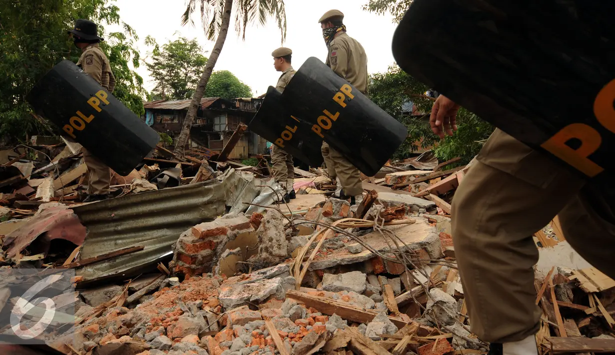 Petugas Satpol PP bersiap mengamankan proses penggusuran rumah warga di Kampung Pulo, Jakarta, Kamis (20/8/2015). 2200 personil gabungan dari Kepolisian dan satpol PP dikerahkan untuk mengamankan penggusuran tersebut. (Liputan6.com/Helmi Fithriansyah)