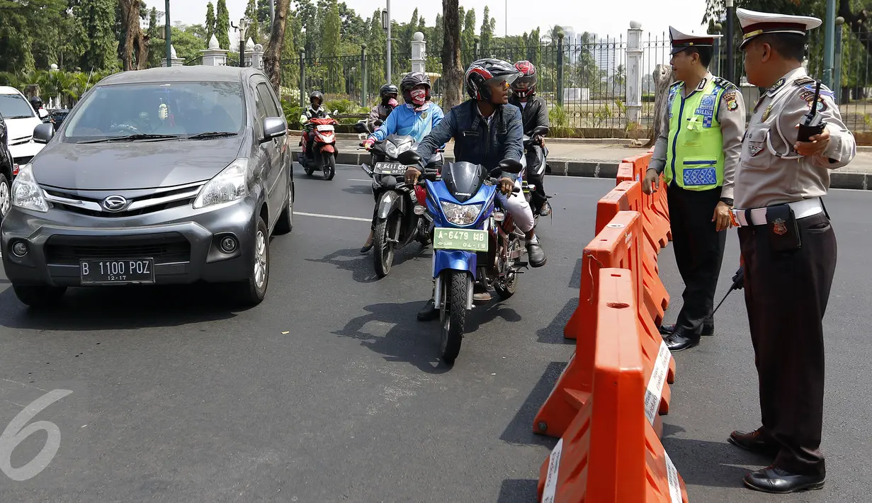 Pengguna jalan mempertanyakan penutupan jalan yang dilakukan petugas polisi di Jalan Medan Merdeka menuju Istana Negara, Jakarta, Jumat (30/10). Penutupan dilakukan akibat demo ribuan buruh yang menolak PP Pengupahan di Istana. (Liputan6.com/Yoppy Renato)