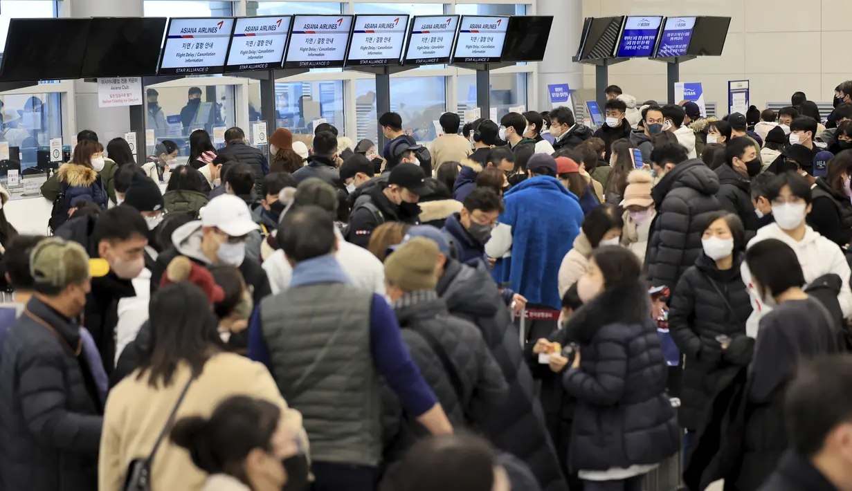 Penumpang menunggu tiket penerbangan mereka di Bandara Internasional Jeju di Pulau Jeju, Korea Selatan, Selasa, 24 Januari 2023. Ribuan pelancong memadati bandara kecil di pulau Jeju Korea Selatan untuk mendapatkan penerbangan setelah penundaan karena kendala angin kencang dan salju tebal.  (Park Ji-ho/Yonhap via AP)