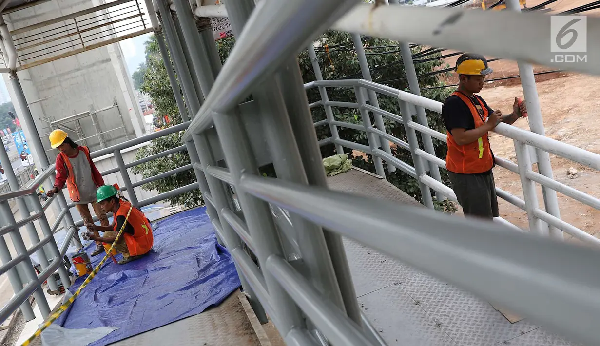 Pekerja mengecat jembatan penyeberangan orang di kawasan Senayan, Jakarta, Jumat (6/7). Pengecatan tersebut merupakan bagian dari proyek revitalisasi JPO guna meningkatnya kenyamanan pejalan kaki. (Liputan6.com/Immanuel Antonius)