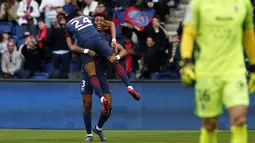 Aksi pemain PSG, Presnel Kimpembe mengnangkat rekannya Christopher Nkunku usai membobol gawang FC Metz pada lanjutan Ligue 1 Prancis di Parc des Princes Stadium, Paris (10/3/2018). PSG menang telak 5-0. (AP/Thibault Camus)