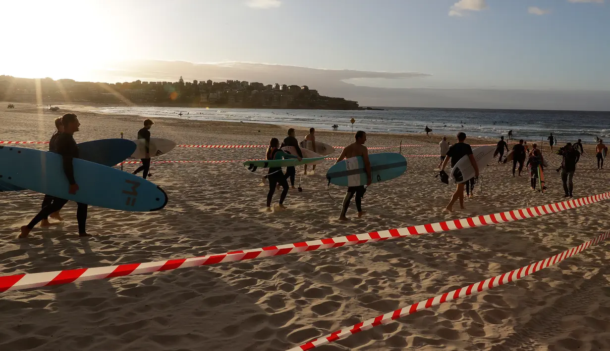 Sejumlah peselancar memenuhi pantai  Bondi di Sydney, Selasa, (28/4/2020). Otoritas setempat mengatakan hanya akan membuka dua pintu yang dapat diakses wisatawan. Walikota Waverley Paula Masseols mengimbau agar warga di luar Bondi tidak mengunjungi pantai tersebut. (AP Photo/Rick Rycroft)