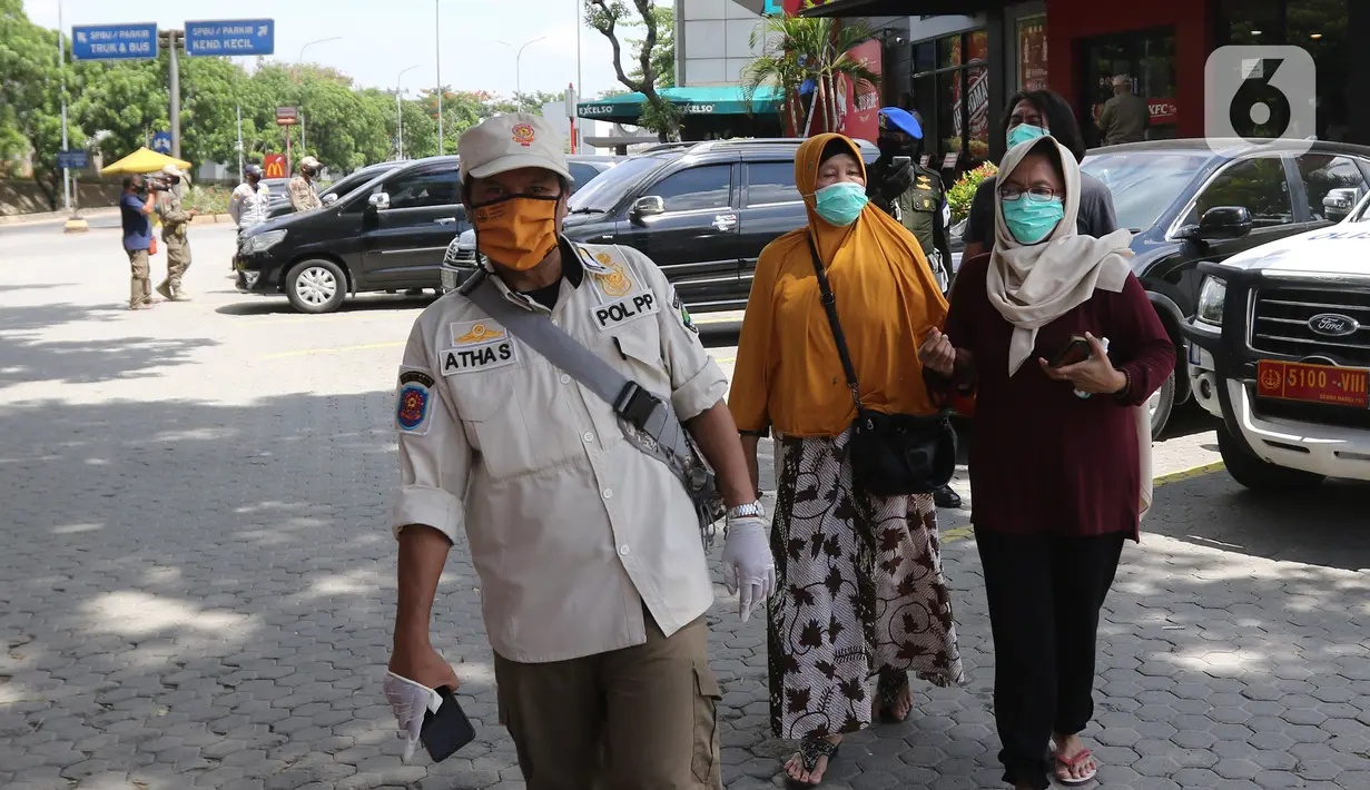 Petugas membawa warga yang tidak bisa menunjukkan hasil  rapid test antigen di Rest Area KM 57, Tol Jakarta-Cikampek, Karawang, Jawa Barat, Kamis (24/12/2020). Warga yang tidak memiliki surat keterangan non reaktif Covid-19 diminta untuk melakukan rapid test antigen. (Liputan6.com/Herman Zakharia)