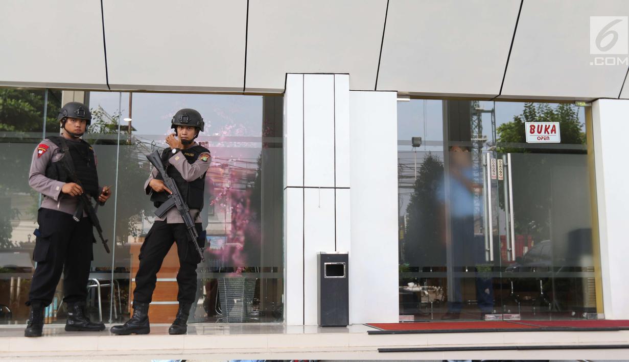 Personel polisi bersenjata laras panjang bersiaga di Pengadilan Negeri Jakarta Selatan pada sidang pembacaan vonis terdakwa terorisme Aman Abdurrahman, Jumat (22/6). Polisi juga menyiagakan penembak jitu di beberapa titik. (Liputan6.com/Angga Yuniar)