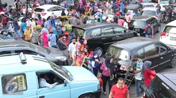 Sejumlah pejalan kaki berjalan di Tanah Abang Jakarta, Sabtu (25/6). Kemacetan tersebut terjadi akibat banyaknya masyarakat yang ingin berbelanja di pasar Tanah Abang untuk memenuhi kebutuhan Idul Fitri. (Liputan6.com/Angga Yuniar)