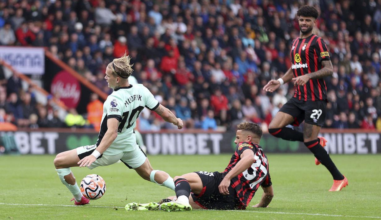 Pemain Chelsea, Mykhaylo Mudryk, terjatuh saat berebut bola dengan pemain Bournemouth, Max Aarons, pada laga Liga Inggris di Stadion Vitality, Minggu (17/09/2023). Chelsea hanya mampu bermain imbang 0-0. (Steven Paston/PA via AP)