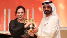 Guru sekolah di tengah wilayah termiskin Inggris, Andria Zafirakou menerima trofi Global Teacher Prize dari Wakil Presiden dan Perdana Menteri UEA, Sheikh Mohammed bin Rashid al-Maktoum dalam acara penganugerahan di Dubai, Minggu (18/3). (AP/Jon Gambrell)