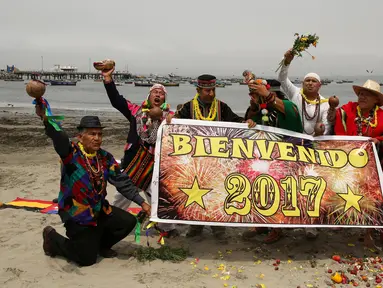Sejumlah dukun asal Peru membentangkan poster prediksi ramalan jelang pergantian tahun di Pantai Agua Dulce di Lima, Peru, (29/12). Para dukun tersebut meramalkan tahun 2017. (Reuters/Mariana Bazo)