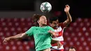 Gelandang Real Madrid, Luka Modric berebut bola udara dengan bek Granada, Ismail Koybasi pada pertandingan lanjutan La Liga Spanyol di stadion Nuevo Los Carmenes di Granada (13/7/2020). Madrid menang tipis 2-1 atas Granada. (AFP/Jorge Guerrero)