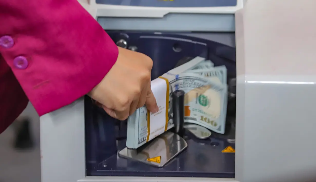Karyawan menghitung lembaran uang Dolar AS di VIP Money Changer, Jakarta, Jumat (5/6/2026). (merdeka.com/Arie Basuki)