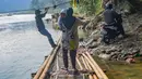 Warga bersiap turun usai menyeberangi Sungai Cisadane menggunakan rakit bambu di kawasan Ciseeng, Kabupaten Bogor, Jawa Barat, Kamis (11/6/2026). (merdeka.com/Arie Basuki)