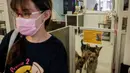 Asisten manajer Tai Po Homing Center Eva Sit mengenakan masker saat memasuki pusat perawatan Hong Kong Dog Rescue (HKDR) di Hong Kong, 14 April 2020. Sejak pandemi Covid-19, kelompok kesejahteraan hewan HKDR berusaha berjuang lantaran semua acara penggalangan dana dibatalkan. (Anthony WALLACE/AFP)