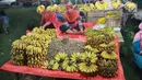 Pedagang menjual pisang dan kacang di pasar malam pada tradisi Malam Qunut di Desa Payunga, Kec. Batudaa, Kab. Gorontalo, Senin (20/5/2019). Tradisi Malam Qunut di Gorontalo dilakukan pada setiap pertengahan bulan Ramadan dengan beramai-ramai memakan pisang dan kacang. (Liputan6.com/Arfandi Ibrahim)