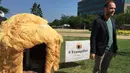 Seorang pria berdiri disamping gubuk yang menyerupai rambut Donald Trump di Cleveland, 19 Juli 2016. Gubuk 'Trump Hut' itu bentuk sindiran kepada Trump yang diyakini bisa memperbesar kesenjangan sosial di AS bila terpilih menjadi presiden. (Nova SAFO/AFP)