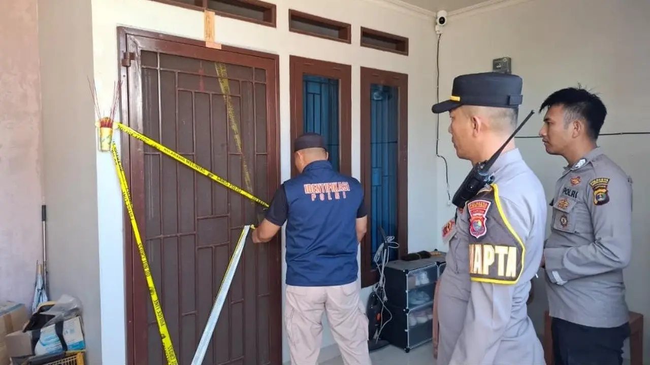 Petugas Kepolisian dari Polresta Bandar Lampung memasang garis polisi di rumah seorang karyawati biro jasa yang diduga jadi korban pembunuhan (Liputan6.com/Ardi Munthe)