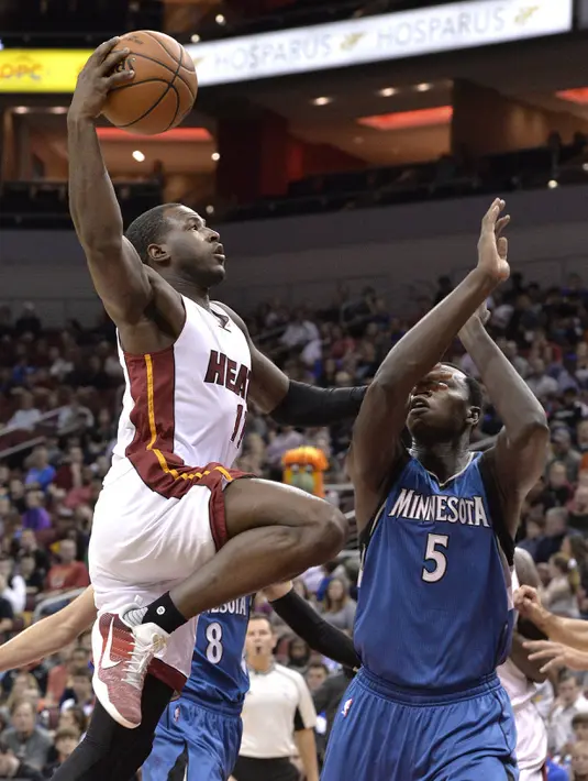 Aksi pemain Miami Heat, Dion Waiters melakukan layup melewati hadangan pemain Minnesota Timberwolves, Gorgui Dieng #5  pada laga NBA preseason basketball game di Louisville, (15/10/2016). (AP/Timothy D. Easley)