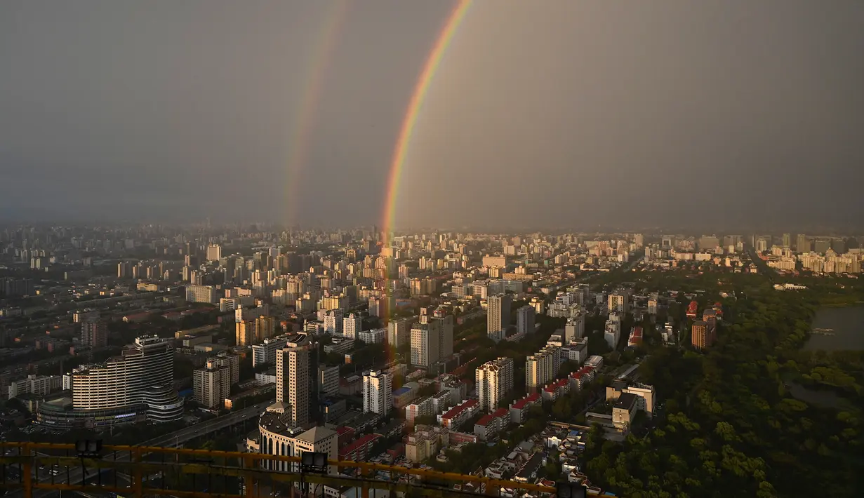Pelangi ganda terlihat dari Central Television Tower di Beijing (26/8/2021). Keindahan pelangi ganda dimanfaatkan warga Beijing untuk diabadikan lewat foto dan berfoto dengan latar pelangi itu. (AFP/Jade Gao)