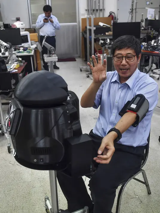 Profesor Viboon Sangveraphunsiri menunjukkan penggunaan robot medis yang dimodifikasi untuk memeriksa pasien virus corona COVID-19 di Regional Center of Robotics Technology, Chulalongkorn University, Bangkok, Thailand, Rabu (18/3/2020). (LILLIAN SUWANRUMPHA/AFP)