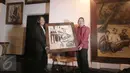 Ketua KEIN, Soetrisno Bachir (kanan) dan pelukis Soehib Toyaroja memegang sebuah lukisan saat acara pembukaan pameran tunggal bertajuk The Spiritual Journey di Kunstkring Art Galeri, Jakarta, Selasa (15/3). (Liputan6.com/Angga Yuniar)
