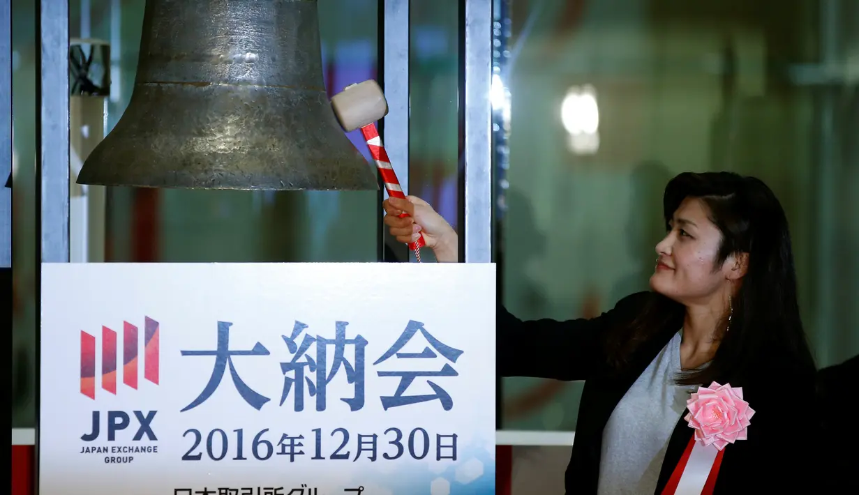 Peraih empat medali emas beruntun Olimpiade asal Jepang, Kaori Icho memukul lonceng menandai penutupan pedagangan bursa saham 2016 di Bursa Efek Tokyo, Jepang, Jumat (30/12). (REUTERS/Toru Hanai)