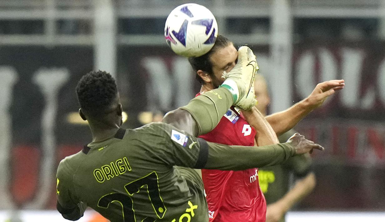 Pemain AC Milan, Divock Origi (kiri) berebut bola dengan pemain Monza, Andrea Barberis saat laga lanjutan Liga Italia 2022/2023 antara AC Milan melawan Monza di Stadion San Siro, Sabtu (22/10/2022). (AP/Luca Bruno)
